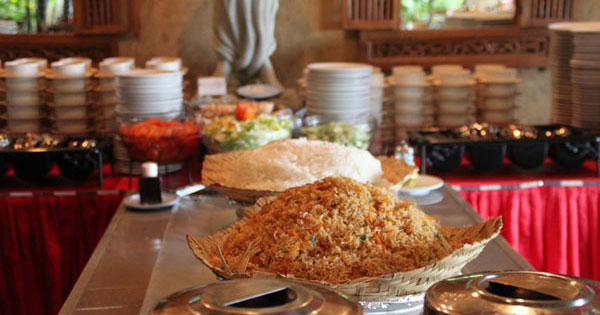 Traditional Balinese fried rice displayed prominently on a buffet table with assorted dishes in a local eatery.