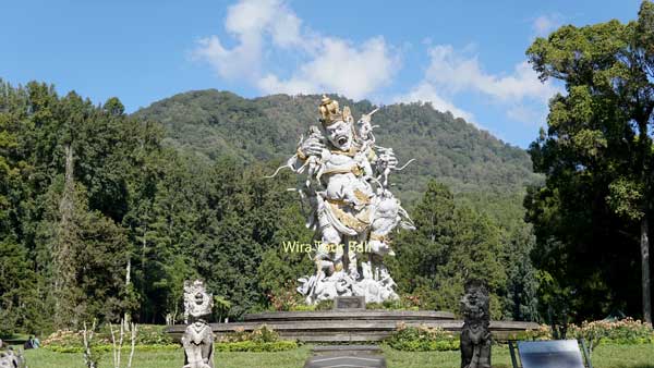 Impressive statue centerpiece at Bali Botanic Garden with lush mountain backdrop.