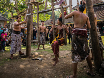 Villagers and visitors gather around traditional swings during a cultural event in Tenganan Village.