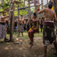 Villagers and visitors gather around traditional swings during a cultural event in Tenganan Village.