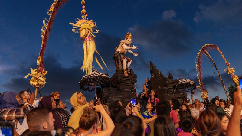 Kecak Dance Performance at Uluwatu Temple with Statue and Audience