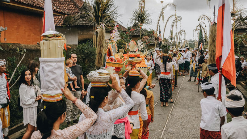 Traditional Balinese parade with women wearing kebaya carrying offerings