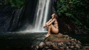 Visitors enjoying a swim in the natural pool at Munduk Waterfall