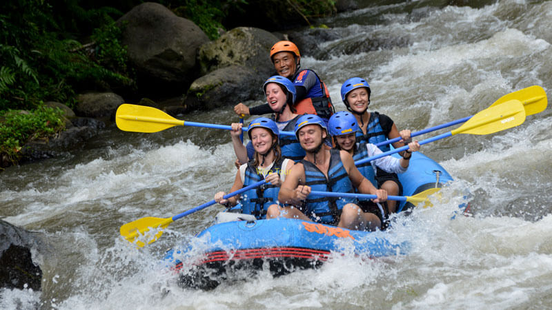 Excited rafters navigating the challenging Telaga Waja River rapids in Bali