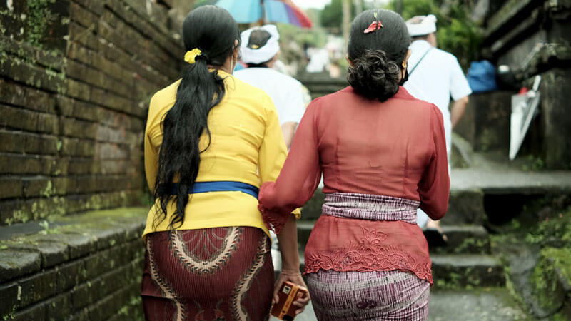 Visitors dressed in traditional sarongs and scarves at Bali Temple.