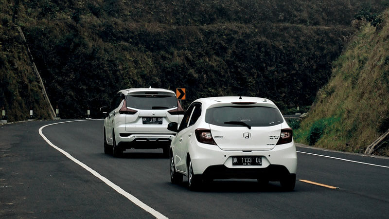 Two cars navigating the curvy mountain roads en route to Bedugul from Denpasar.