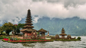 Scenic view of Pura Ulun Danu Bratan Temple with multi-tiered shrines on Lake Bratan, surrounded by the lush green mountains of Bedugul, Bali.