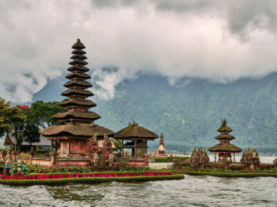 Scenic view of Pura Ulun Danu Bratan Temple with multi-tiered shrines on Lake Bratan, surrounded by the lush green mountains of Bedugul, Bali.