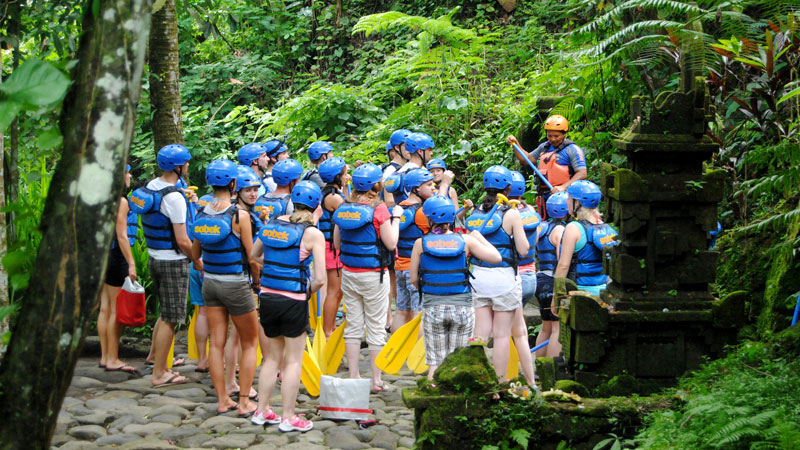 Group of rafters in safety gear attending a briefing before river rafting in Bali