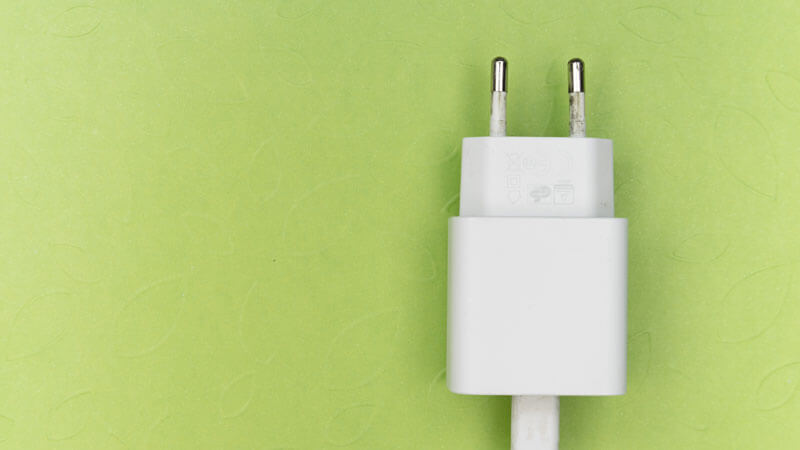 European-style two-pin plug adapter on a green background.