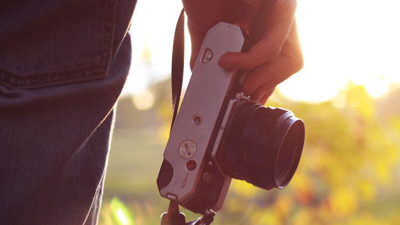 Photographer holding a camera during golden hour