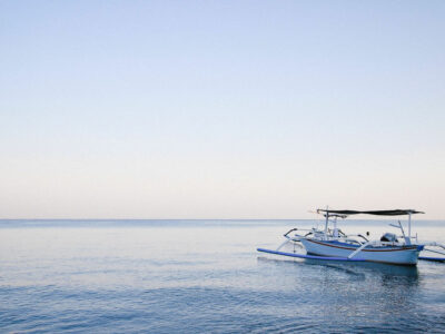 Traditional Balinese boat floating on the calm waters of Lovina Beach at dawn