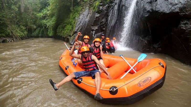 Joyful rafters by a waterfall on Ayung River with Payung Rafting Ubud