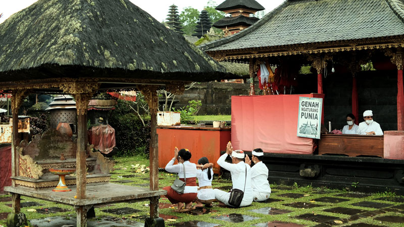 Local devotees offering prayers at Mother Temple of Bali, respecting cultural and spiritual practices.