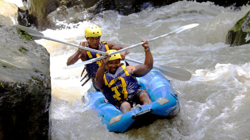 Adventurers kayaking through the challenging rapids of Ayung River in Ubud with Mason Adventure Rafting.