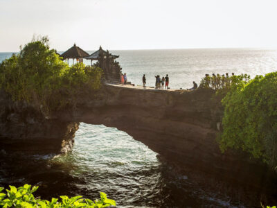 Visitors at Batu Bolong Temple with its unique rock arch over the sea