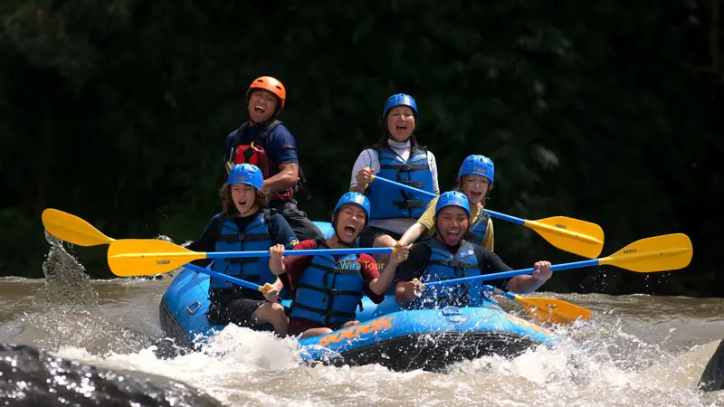 Tourists rafting on Ayung River Ubud, enjoying thrilling rapids and lush surroundings.