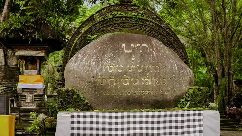 Ancient stone inscription at a sacred Balinese water temple, highlighting its spiritual and historical significance.