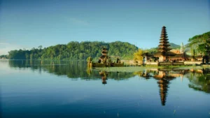 Early morning calm over Lake Beratan Bedugul Bali with clear water and blue sky reflection.