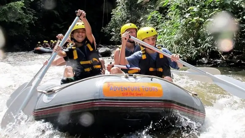 Family with children rafting calmly on Ayung River in clear weather