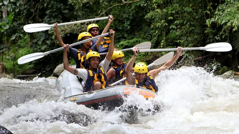 Group rafting Ayung River in Bali during rainy season with intense rapids and high adrenaline