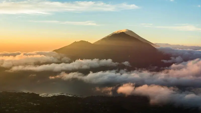 Sunrise view of Mount Agung seen from Mount Batur summit with clouds below
