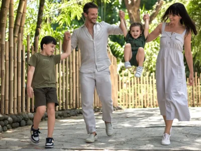 Family walking together on shaded path at Bali Zoo with young children