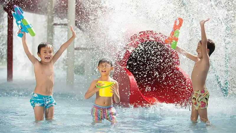Kids playing under water jets at Jungle Splash zone in Bali Zoo