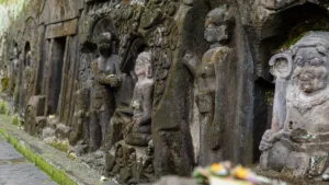 Ancient stone relief figures carved into a cliff at Yeh Pulu Temple Ubud
