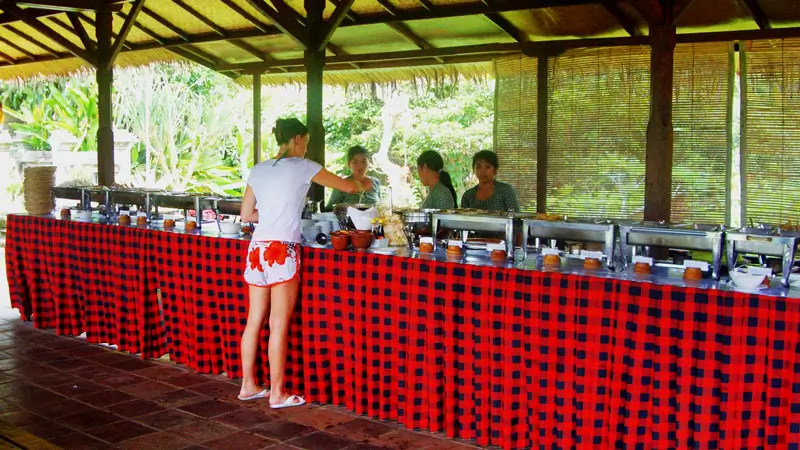 Indonesian buffet lunch served in open-air riverside dining area after rafting.