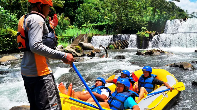 Sobek rafting guide briefing guests at Telaga Waja River before rapids, part of the day itinerary and safety routine.