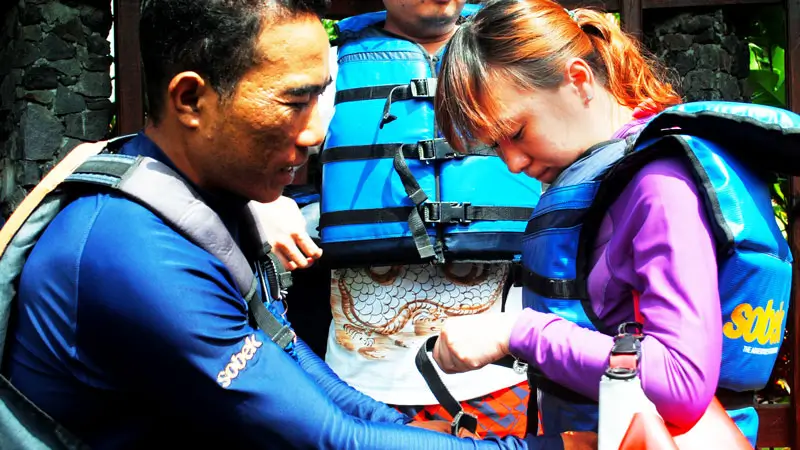 Guide fitting lifejacket on a Bali rafting for beginners trip.