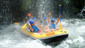 Happy Sobek rafting group on Telaga Waja River in Bali raising paddles after completing a fun whitewater section.