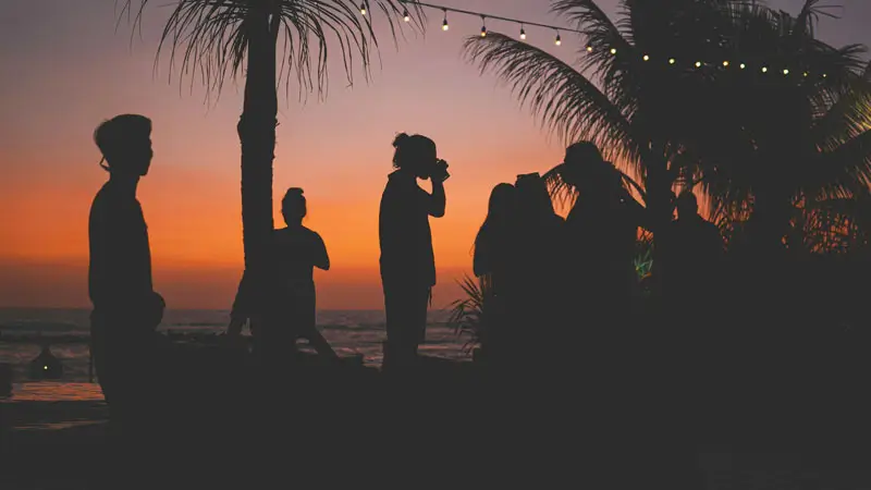 Sunset crowd silhouettes at a beach bar during late December in Bali