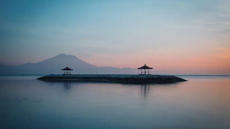 Calm sunrise at an east-side bay in Bali in December with Mount Agung silhouette