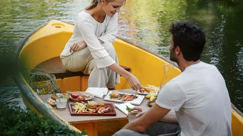 Couple enjoying lunch on a yellow boat at Kamandalu lagoon