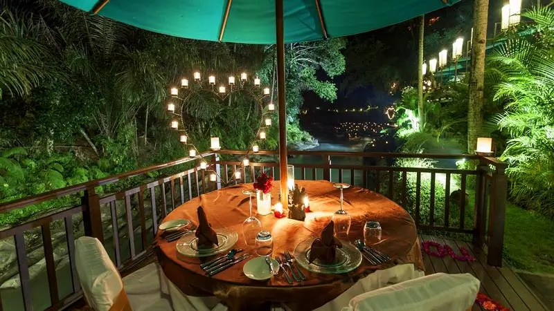 Romantic candlelight dinner table by the Ayung River at Swept Away for honeymoon couples
