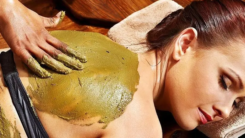 Woman enjoying body scrub spa treatment, popular with honeymoon couples