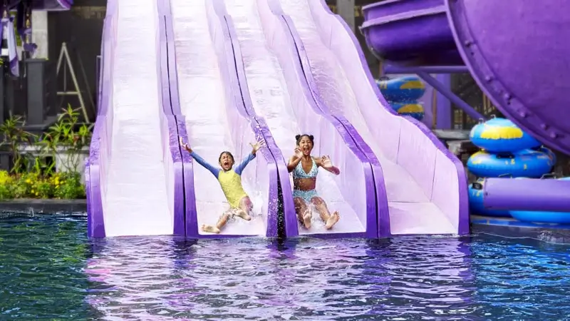Kids on straight water slides at the waterpark pool