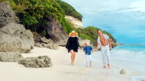Family walking on a quiet Bali beach with kids