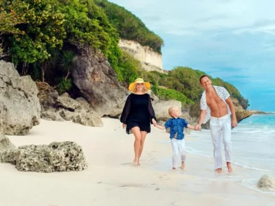 Family walking on a quiet Bali beach with kids