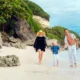 Family walking on a quiet Bali beach with kids