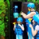 Parent with two children wearing helmets and life jackets before kids rafting
