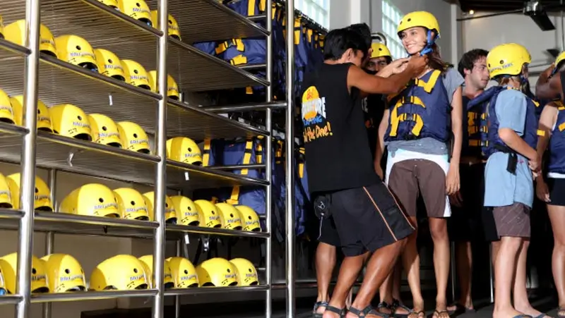 Staff fitting helmets and life jackets before the kayaking session