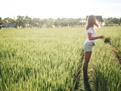Traveler in a white T-shirt and shorts in a sunny Bali rice field