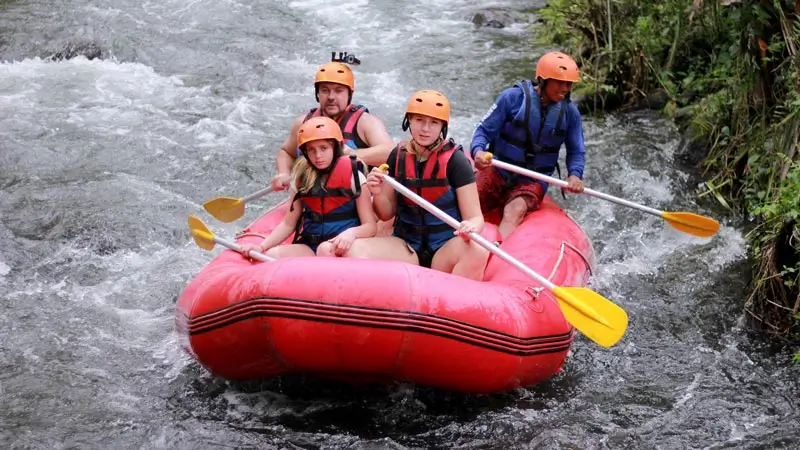 Rafting boat with a guide and guests on a narrow river