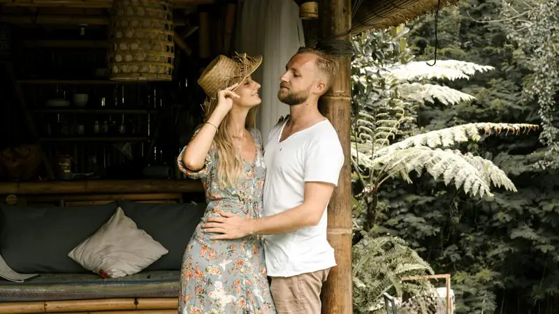 Couple standing beside a bamboo-style villa