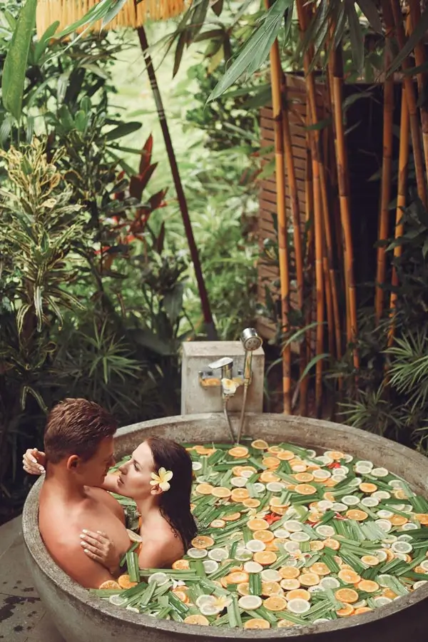 Couple relaxing in a flower bath at a tropical spa
