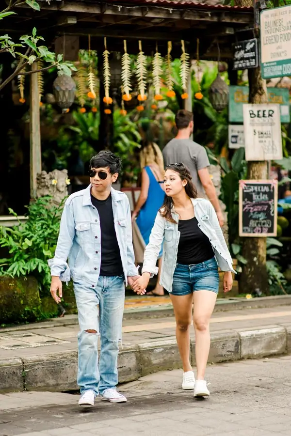 Couple walking near cafes on a village street