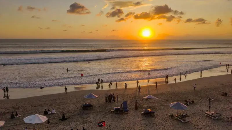 Travelers watching sunset on a Bali beach